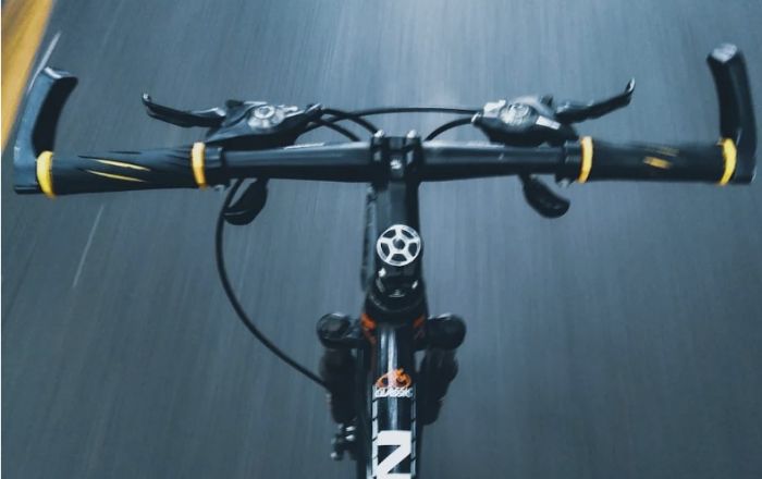 Ciclista sfreccia tra le auto e colpisce un triestino