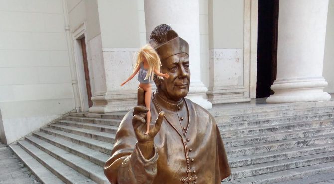 Curiosità in piazza Sant'Antonio, vescovo Santin con una Barbie in mano: morbin o blasfemia?