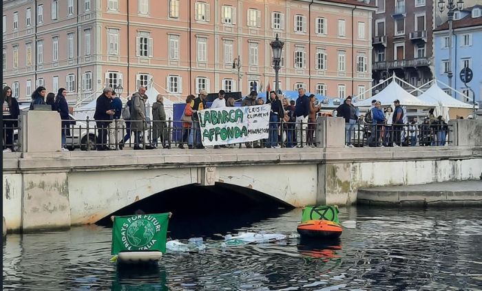 Ambientalisti nel Canal Grande in piena Barcolana con striscione “La Barca Affonda, Crisi Climatica=Migrazioni"