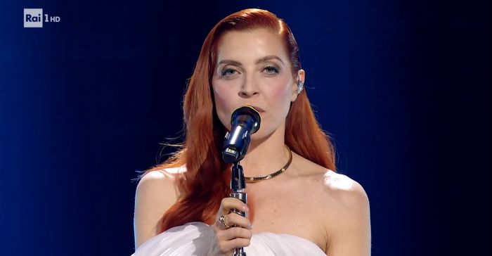 Noemi scende le scale aiutata da Carlo Conti